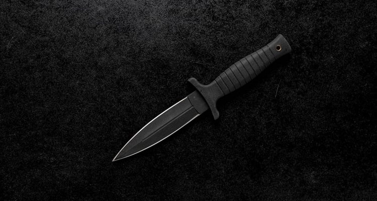 A closeup shot of a fixed sharp knife on a black background