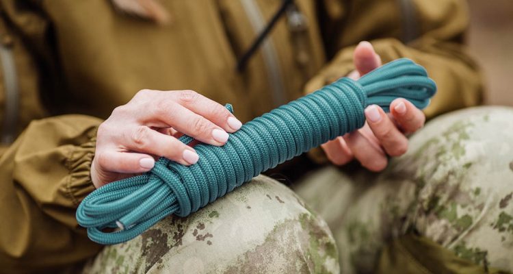 close up of female hands tie a rope. war, hiking, army and people concept